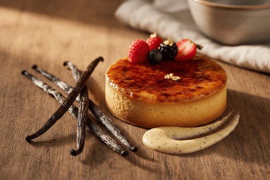 Gousses de vanille Vanille 77 avec dessert crème et fruits rouges sur table en bois